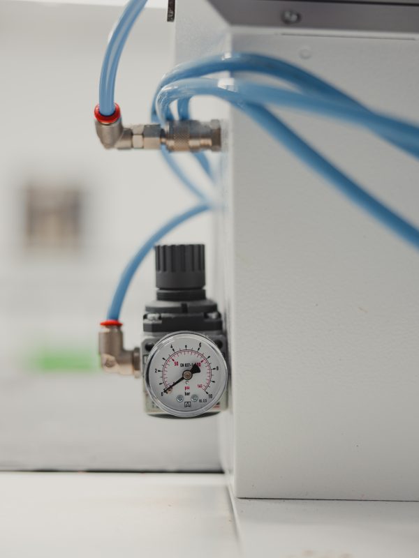 Close-up of a pressure gauge on a white wall in a factory