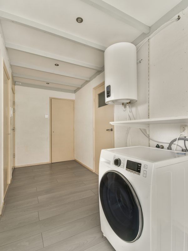 Narrow corridor with doors and washing machine