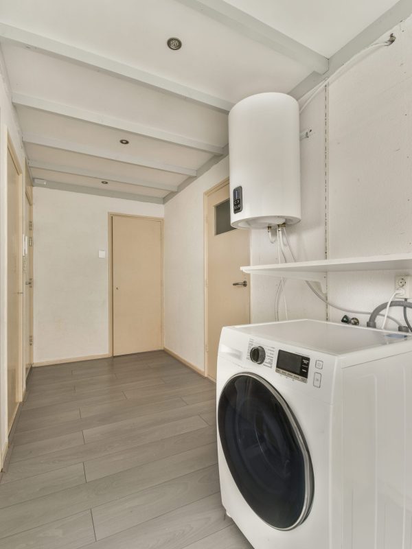 Narrow corridor with doors and washing machine