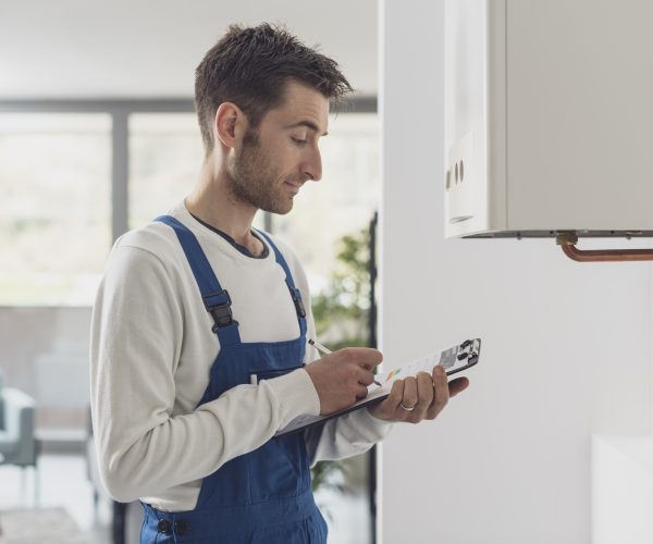 Professional plumber doing a boiler check