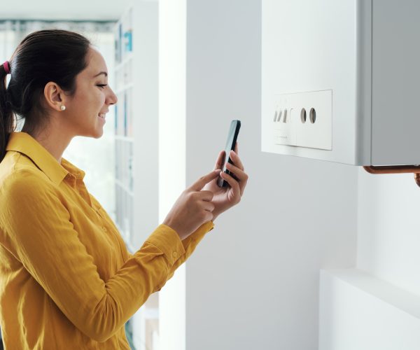 Woman managing her smart boiler using her phone